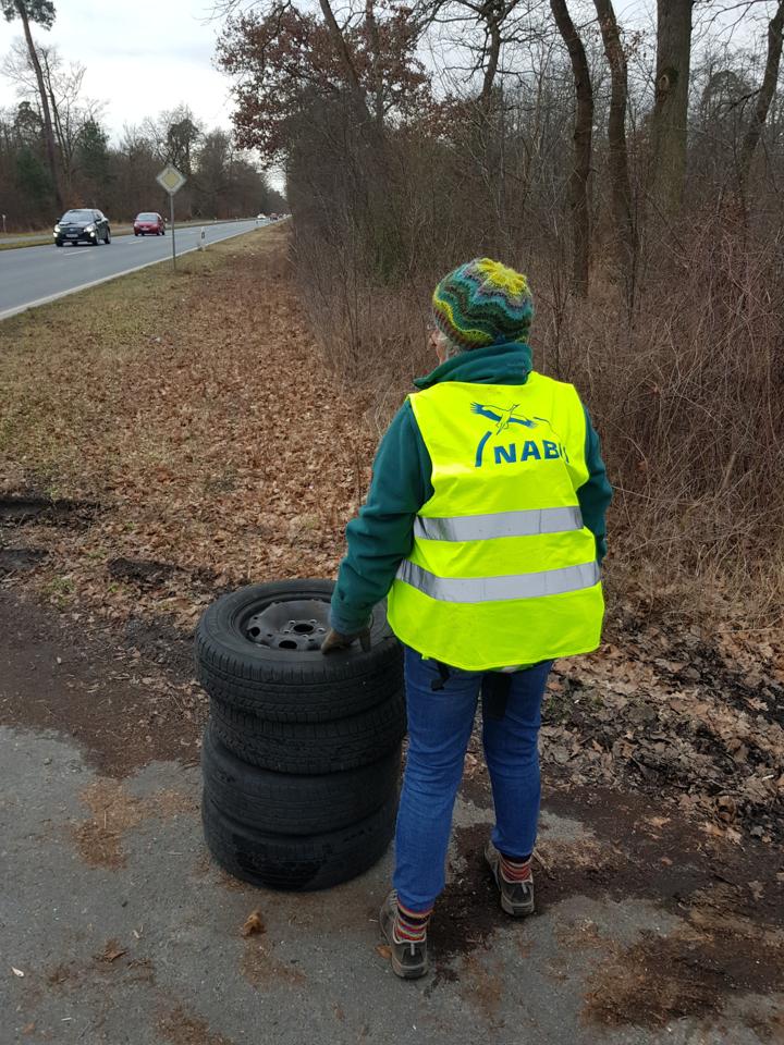 Kirstin mit NABU-Warnweste neben dem Reifenstapel.