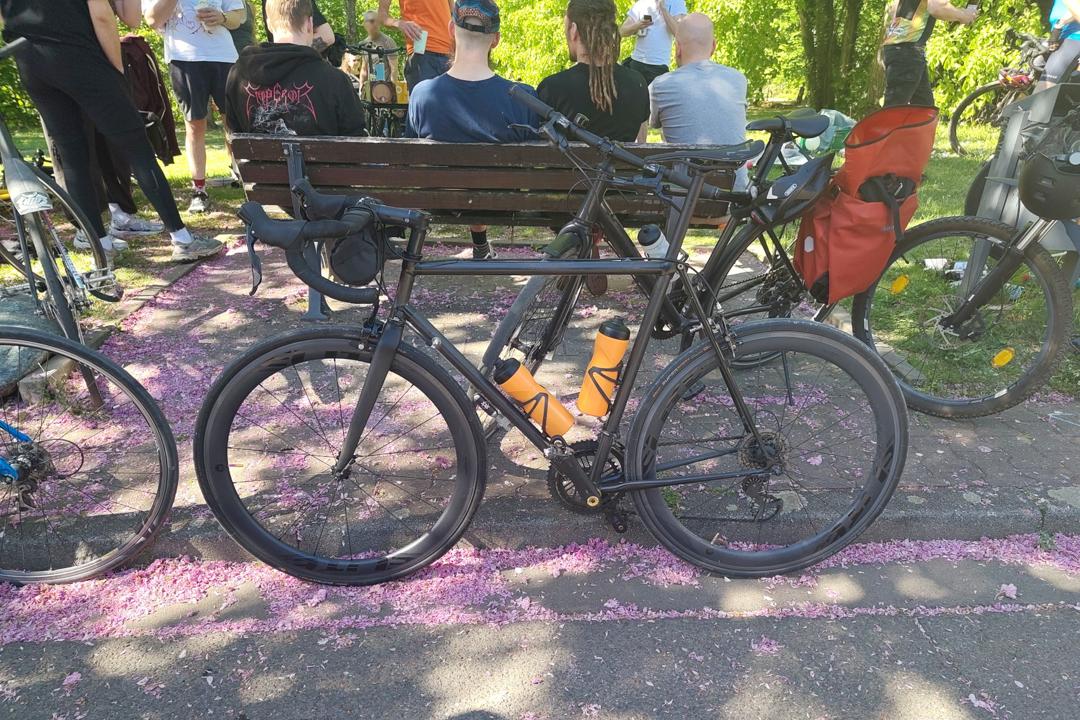 Koga-Miyata lehnt mit zwei Trinkflaschen an einem Bordstein.