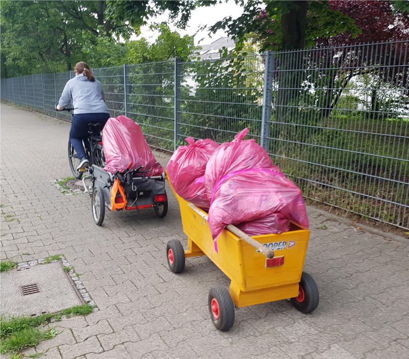 Kiara zieht den Fahrradanhaenger und Waste-Buster mit dem Fahrrad.