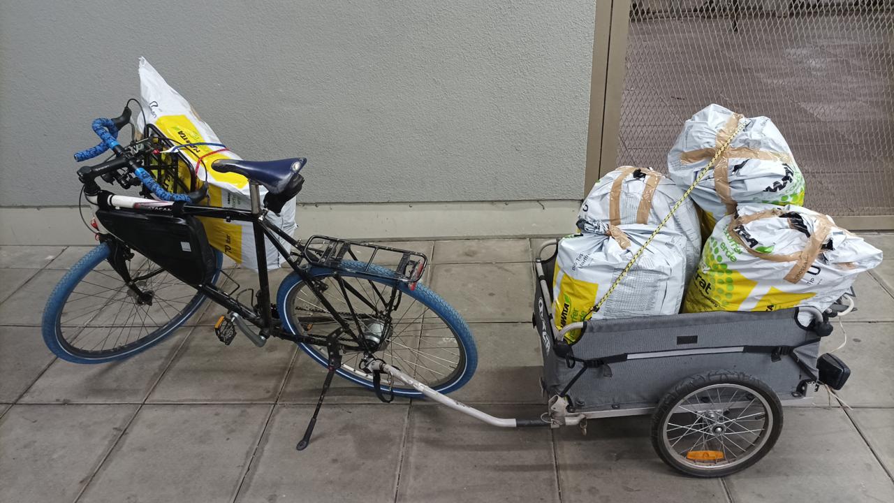 Rad mit Anhaenger beladen mit Muellsaecken