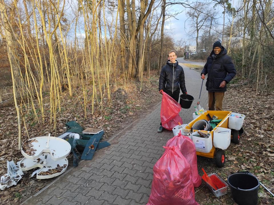 Ein Teil der Cleanupcrew neben dem Waste-Buster, umgeben von Muell.