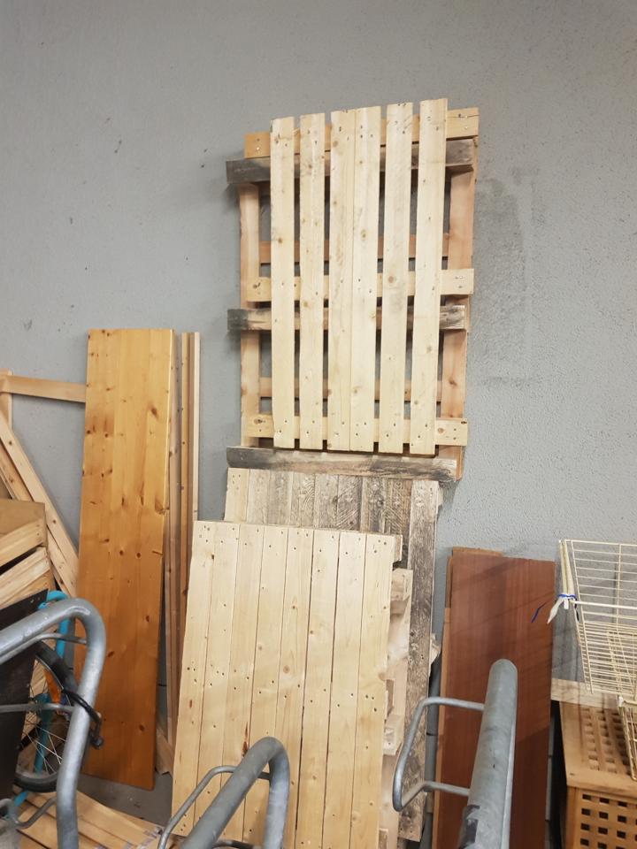 Gespendete Paletten stehen angelehnt in der Fahrradgarage.