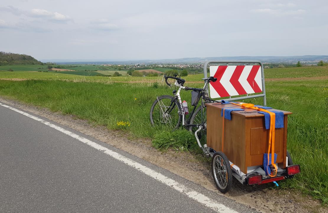 Frankenstein with trailer on which sits a chest, strapped down.